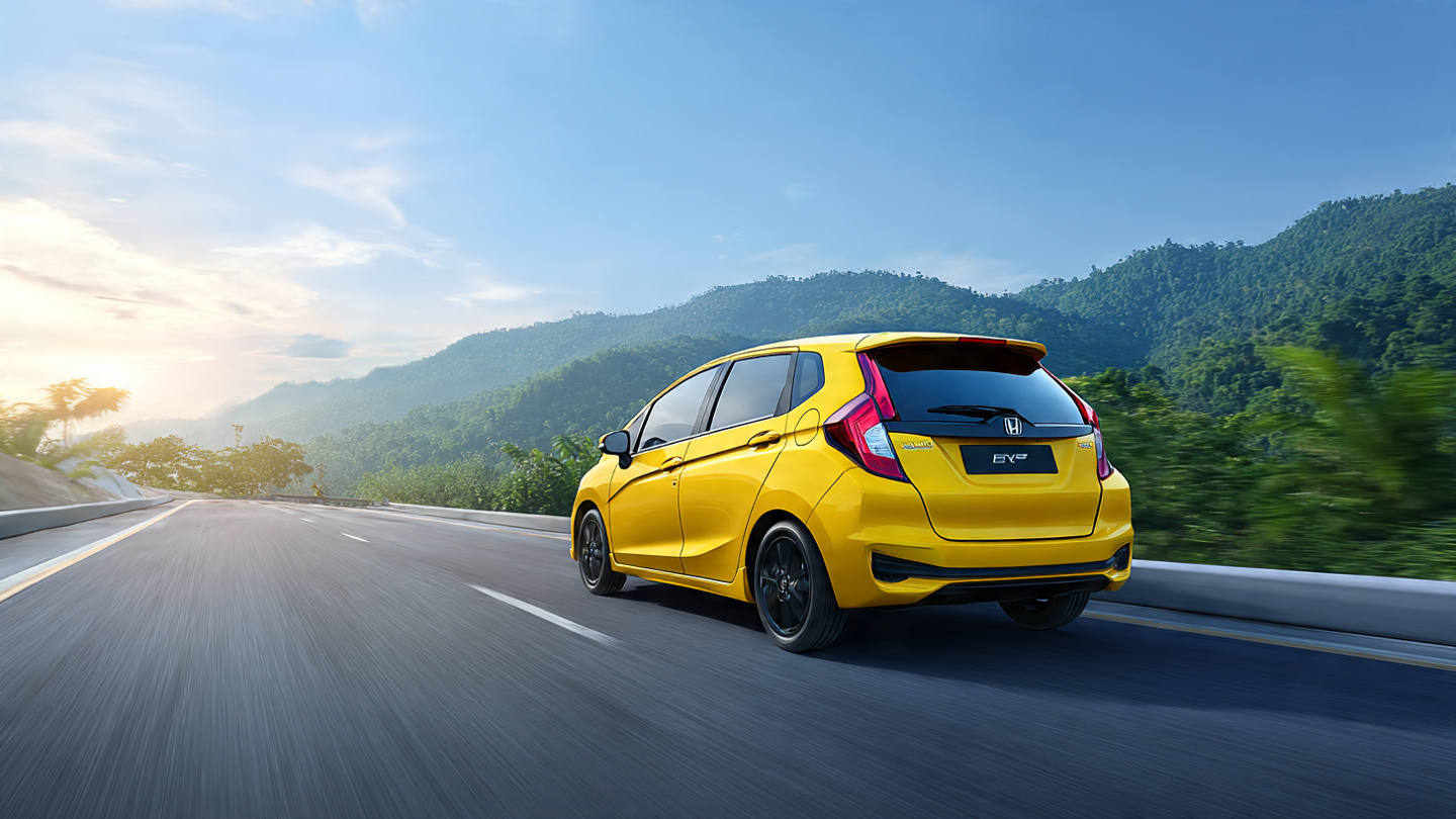 Honda Jazz едет по шоссе недалеко от Паттайи среди зелёных холмов